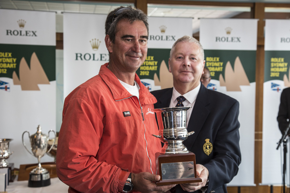 A crew member from Lahana collects the trophy for being third over the line from RYCT Commodore Graham Taplin