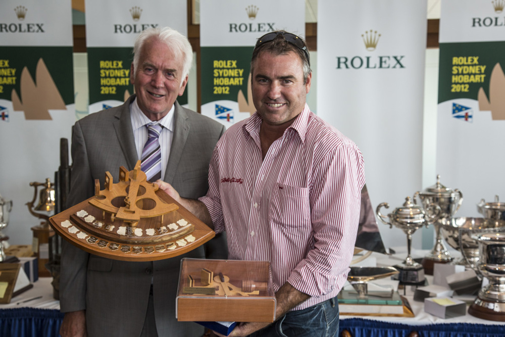 John Hildebrand accepts the Bill Owen Memorial Trophy for the navigator of the winning yacht, Wild Oats XI, from Damon Thomas, Lord Mayor of Hobart