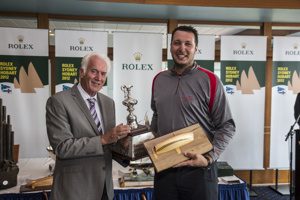 Peter Mosley, Local Hero, accepts the Battery Point Trophy for the first small boat across the line, from Damon Thomas, Lord Mayor of Hobart