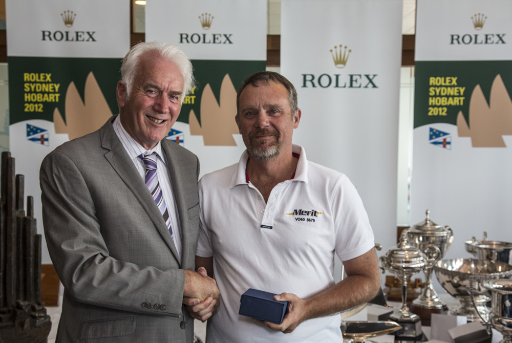 A crew member from Merit accepts the trophy for Merit's third in PHS division 1 from Damon Thomas, Lord Mayor of Hobart