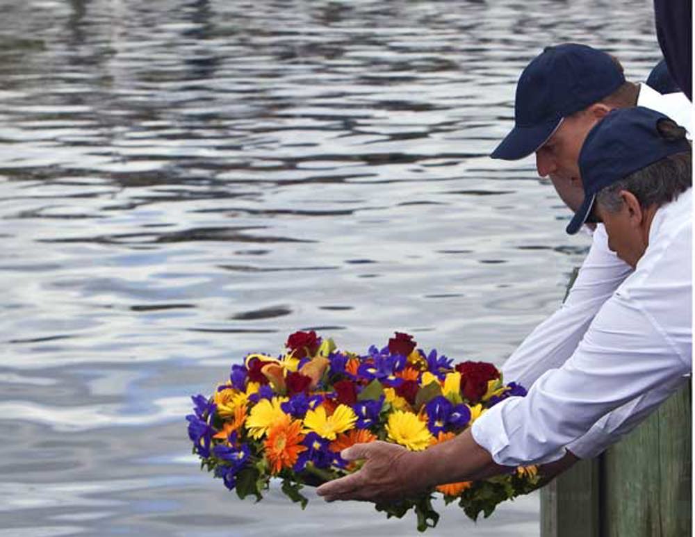 CYCA Commodore Matt Allen and RYCT Commodore Clive Simpson placing the commemorative wreath into the water for the 6 sailors lost in 1998 and for all others lost at sea as a result of undertaking a Hobart race.