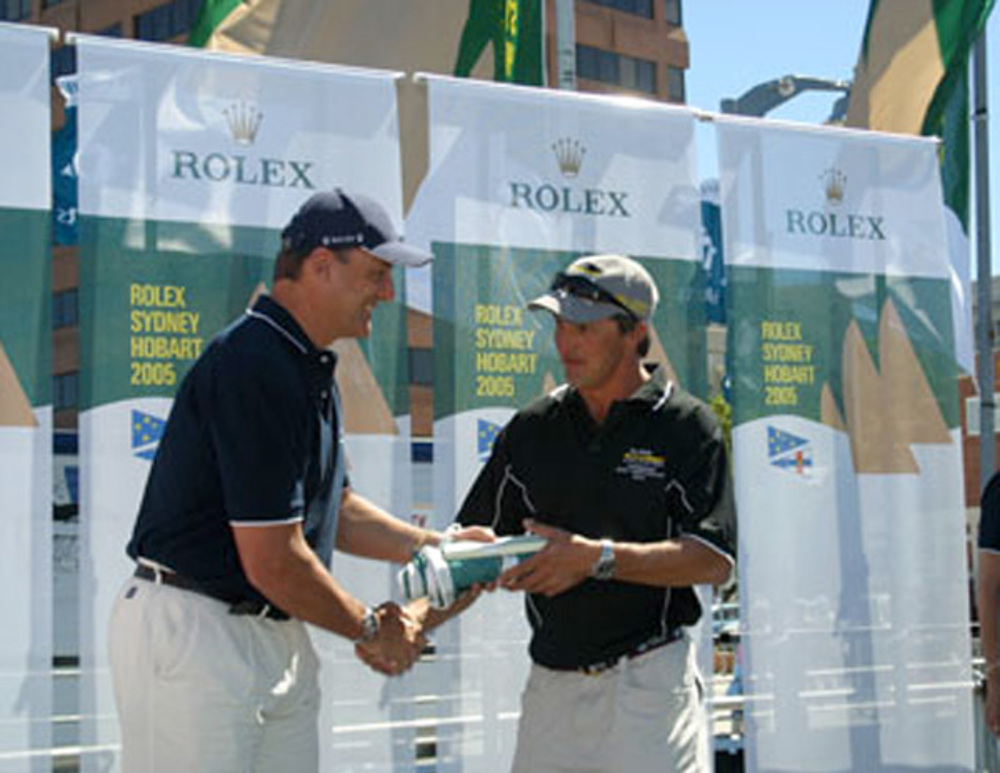 Mike Freebairn, skipper of Ray White Koomooloo, accepts the divisional winners battle flag from Matteo Mazzanti of Rolex