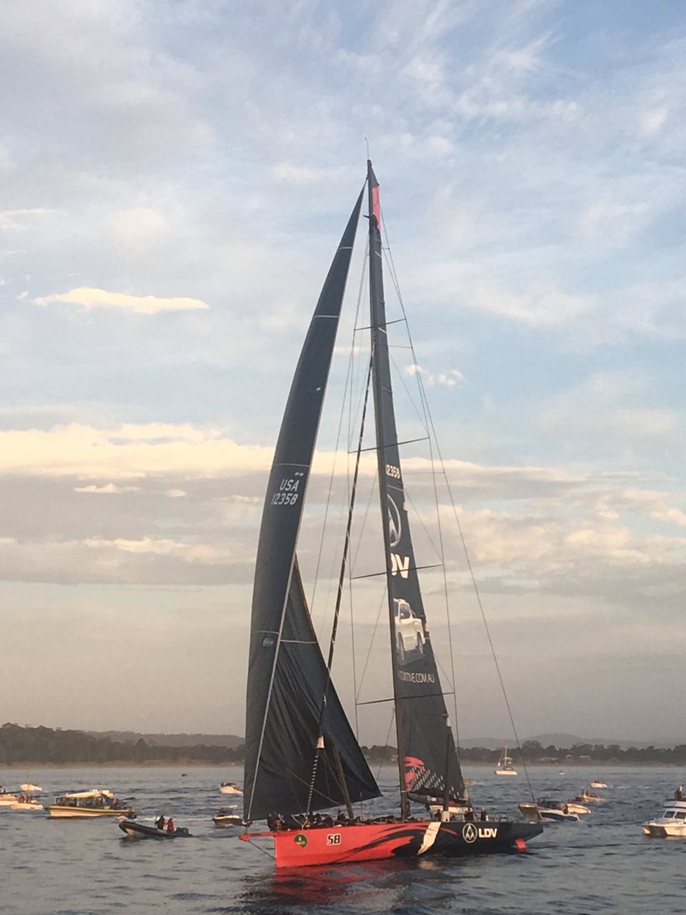 LDV Comanche in sight of the finish, and with a crewman up the mast looking for breeze