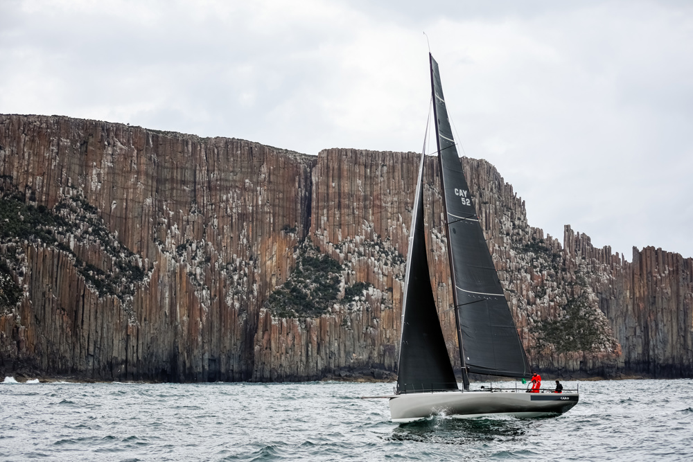 Caro with the spectaculr backdrop of Cape Raoul.     Image: CYCA | Salty Dingo