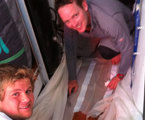 Ben and James in the Galley Mending Exile's Sails. Ben smelt dinner cooking, opened the oven door and the lasagne promptly flew out of the oven and onto the sail!