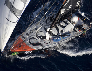 Alex Thomson's UK entry Hugo Boss powering downwind at sunrise on day 2 of the Rolex Sydney Hobart