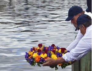 CYCA Commodore Matt Allen and RYCT Commodore Clive Simpson placing the commemorative wreath into the water for the 6 sailors lost in 1998 and for all others lost at sea as a result of undertaking a Hobart race.
