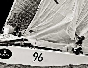 Crew members onboard Vamp take down the spinnaker near the Organ Pipes