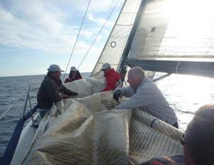 Justin, Rob and Kiwi folding the sails after a sail change on Exile