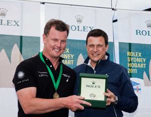 Anthony Bell accepts the Rolex timepiece from Patrick Boutellier, Rolex Australia