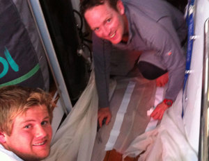 Ben and James in the Galley Mending Exile's Sails. Ben smelt dinner cooking, opened the oven door and the lasagne promptly flew out of the oven and onto the sail!