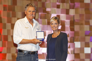 The Honourable Elise Archer MP presenting the 25 race medallion to Jim Nixon